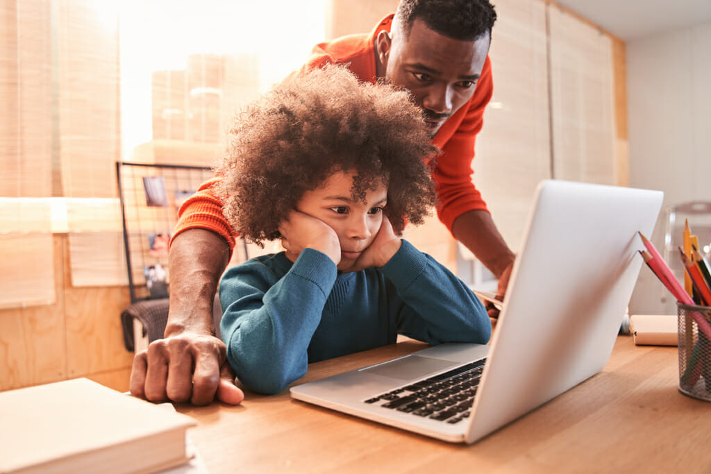 Black father helps frustrated child with distance learning Black father helps frustrated child with distance learning